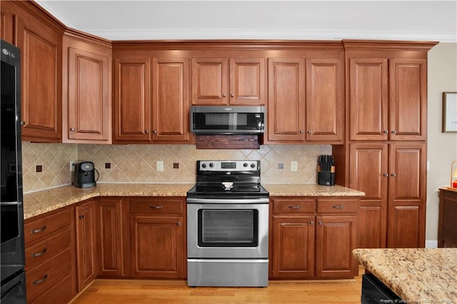 kitchen with stainless steel appliances, brown cabinetry, backsplash, light stone counters, and crown molding