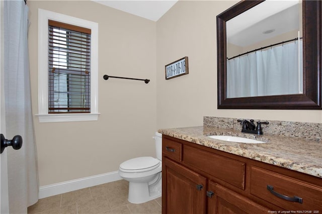 bathroom with baseboards, vanity, tile patterned floors, and toilet