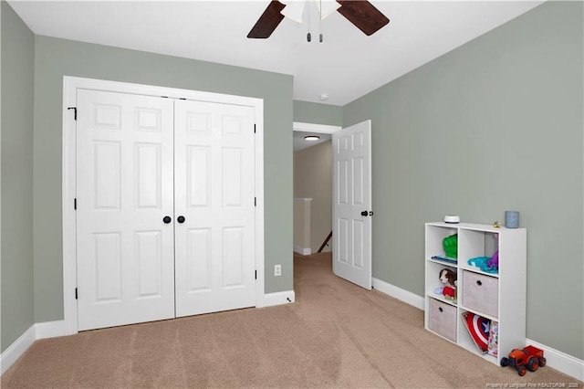 carpeted bedroom with baseboards, a closet, and a ceiling fan