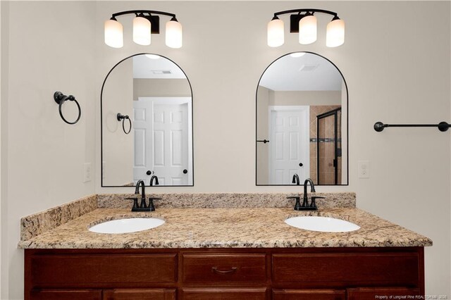 full bathroom featuring double vanity and a shower stall