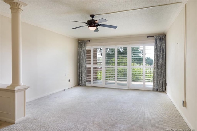 unfurnished room featuring a ceiling fan, ornate columns, carpet floors, a textured ceiling, and ornamental molding