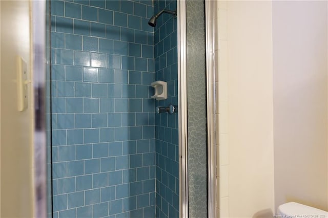 interior details featuring a stall shower and toilet