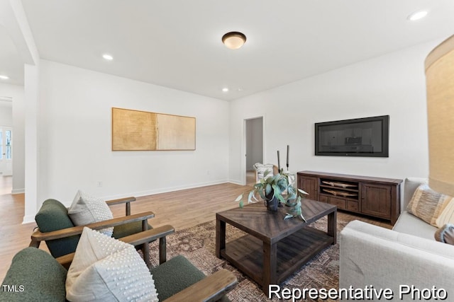 living area featuring recessed lighting, baseboards, and light wood-type flooring