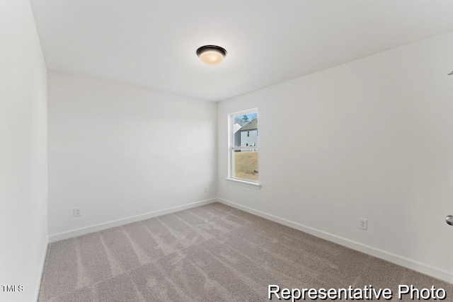 carpeted empty room featuring baseboards