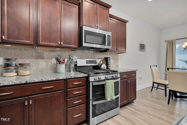 kitchen featuring appliances with stainless steel finishes, backsplash, ornamental molding, light wood finished floors, and light stone countertops