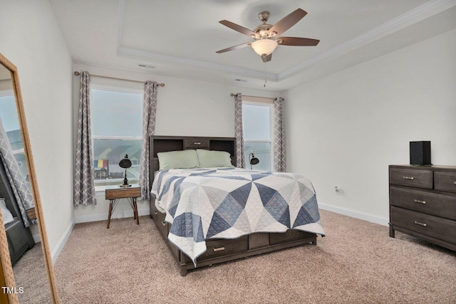 bedroom with carpet floors, a raised ceiling, ornamental molding, baseboards, and ceiling fan