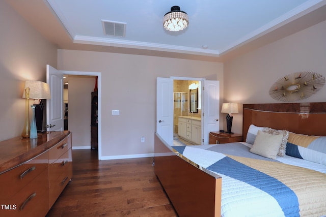 bedroom featuring a raised ceiling, dark wood-type flooring, baseboards, a chandelier, and connected bathroom