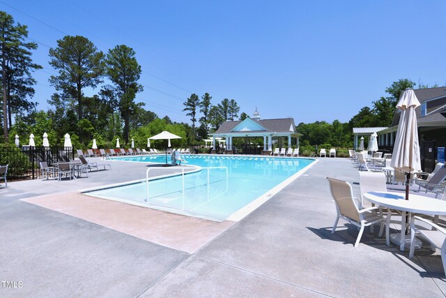 community pool featuring fence and a patio area