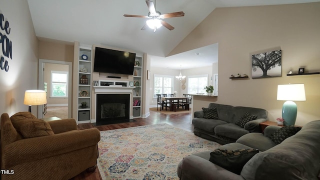 65 Wood Green Dr, Wendell, NC 27591 - living room featuring lofted ceiling, dark wood-style flooring, a fireplace with flush hearth, and ceiling fan with notable chandelier