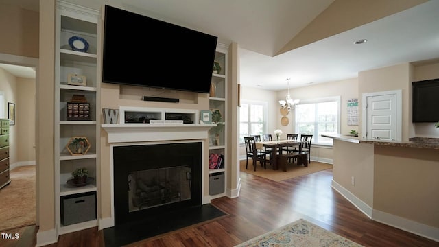 65 Wood Green Dr, Wendell, NC 27591 - living room featuring a chandelier, dark wood-style flooring, baseboards, and a fireplace with flush hearth