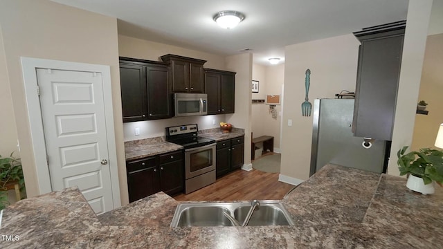 65 Wood Green Dr, Wendell, NC 27591 - kitchen with baseboards, dark brown cabinetry, a sink, wood finished floors, and appliances with stainless steel finishes