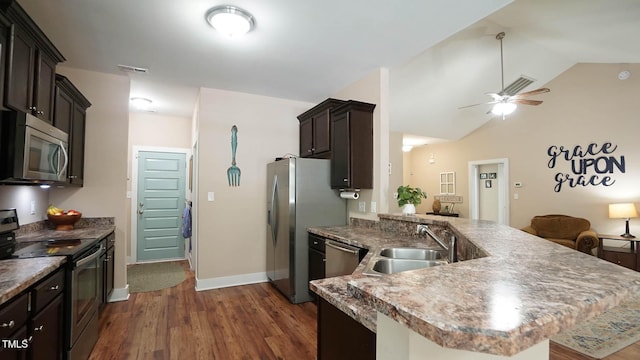65 Wood Green Dr, Wendell, NC 27591 - kitchen with a peninsula, a sink, dark wood-type flooring, appliances with stainless steel finishes, and lofted ceiling