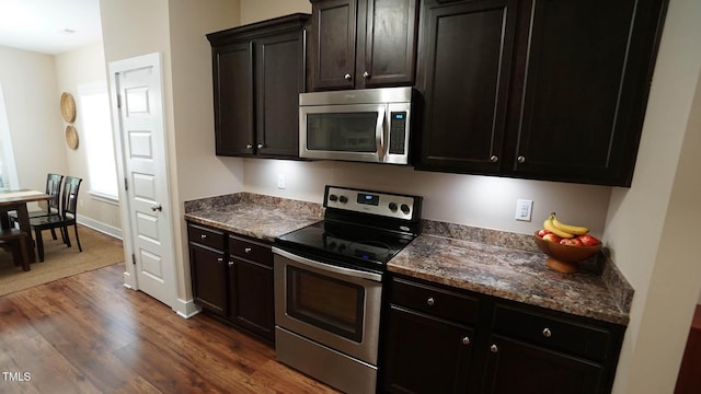 65 Wood Green Dr, Wendell, NC 27591 - kitchen with baseboards, stainless steel appliances, dark wood finished floors, and dark stone counters