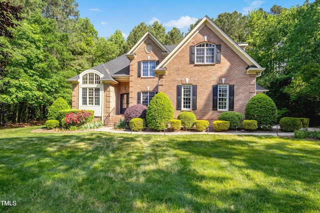 traditional home featuring a front lawn and brick siding