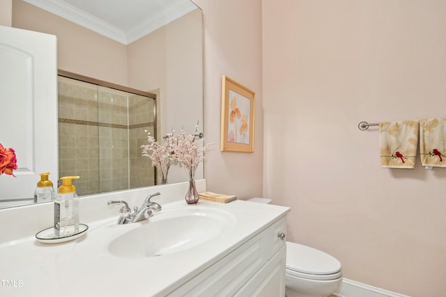 bathroom with toilet, a tile shower, vanity, and crown molding
