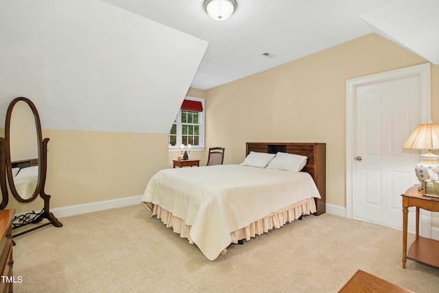 bedroom featuring lofted ceiling, baseboards, visible vents, and carpet floors