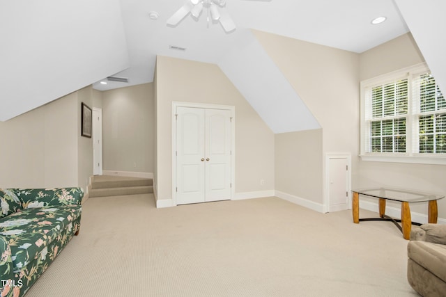 interior space featuring light carpet, visible vents, baseboards, ceiling fan, and vaulted ceiling