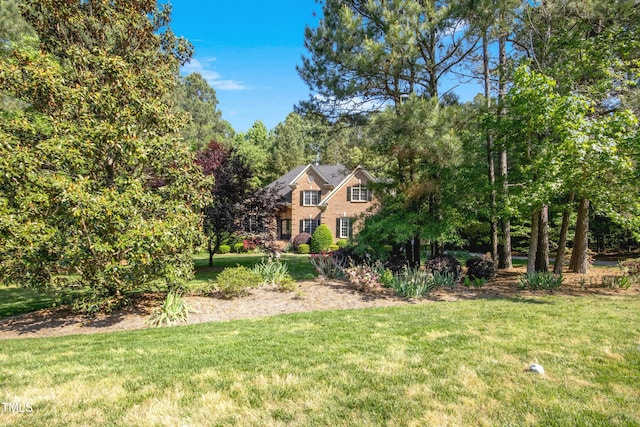 view of front of property with a front lawn and brick siding