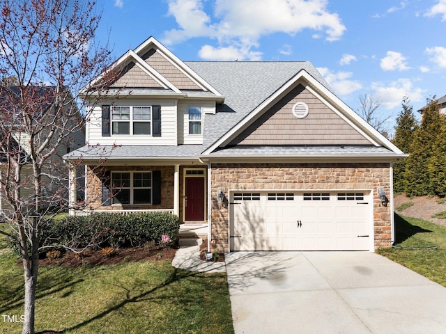 craftsman inspired home with driveway, stone siding, a garage, and a front lawn