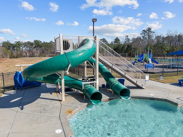 view of jungle gym featuring fence and view of scattered trees