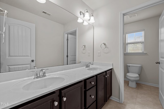 full bath with double vanity, tile patterned floors, baseboards, and toilet