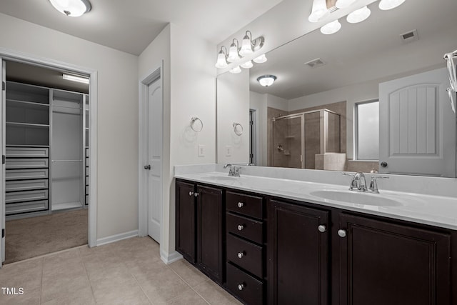 full bath with a stall shower, tile patterned floors, double vanity, baseboards, and a closet