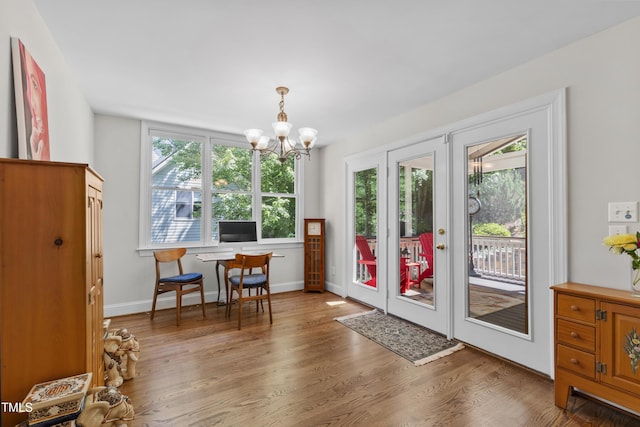 dining area with a chandelier, wood finished floors, baseboards, french doors, and an office area