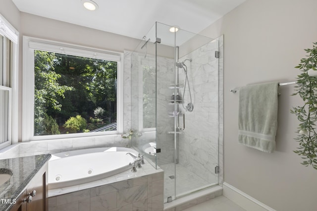 full bathroom with a tub with jets, a stall shower, vanity, and baseboards