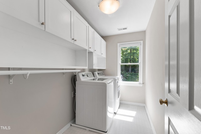 washroom featuring washer and dryer, cabinet space, and baseboards