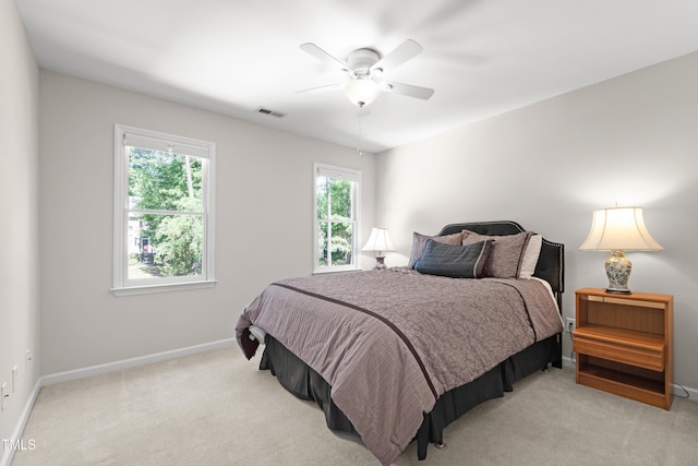 bedroom featuring baseboards, light colored carpet, and ceiling fan