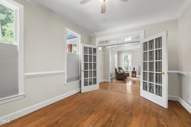 spare room featuring french doors, crown molding, wood finished floors, a ceiling fan, and baseboards
