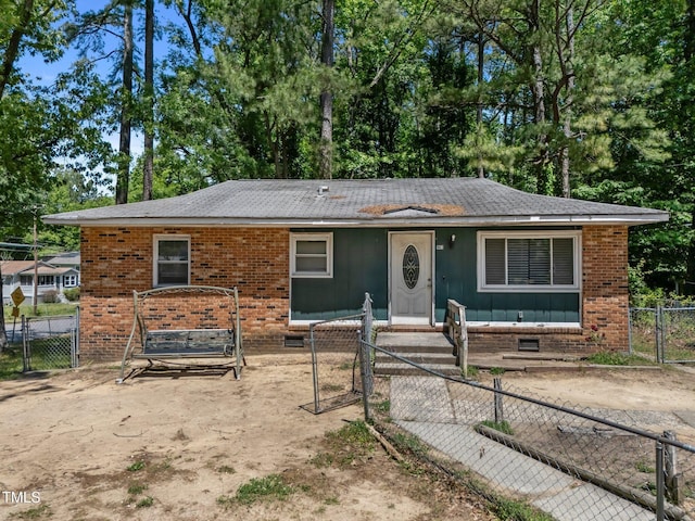 view of front of house with a gate, brick siding, a fenced front yard, and a shingled roof