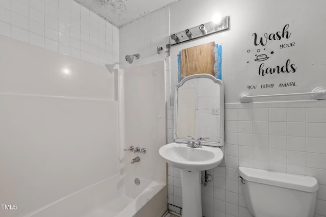 bathroom featuring shower / bathtub combination, toilet, and tile walls