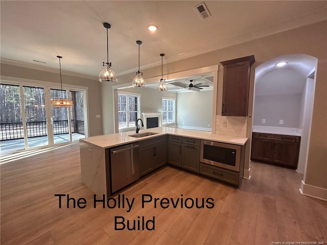 194 Landon Rdg, Sanford, NC 27330 - kitchen with appliances with stainless steel finishes, light wood finished floors, ornamental molding, hanging light fixtures, and a peninsula