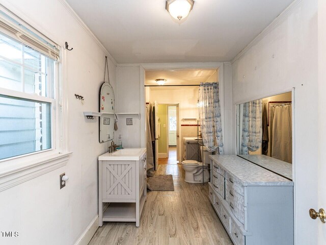 full bath with vanity, toilet, a healthy amount of sunlight, and wood finished floors