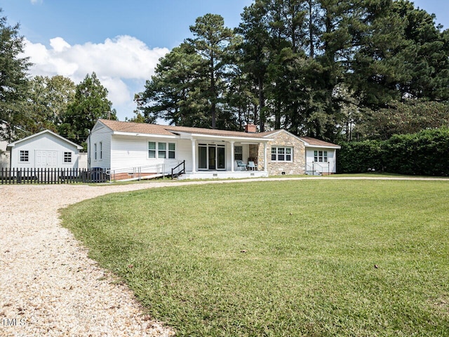 view of front facade featuring a chimney, fence, gravel driveway, a front yard, and a porch
