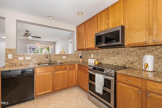 776 Averasboro Dr, Clayton, NC 27520 - kitchen with a sink, brown cabinets, light stone counters, a ceiling fan, and appliances with stainless steel finishes