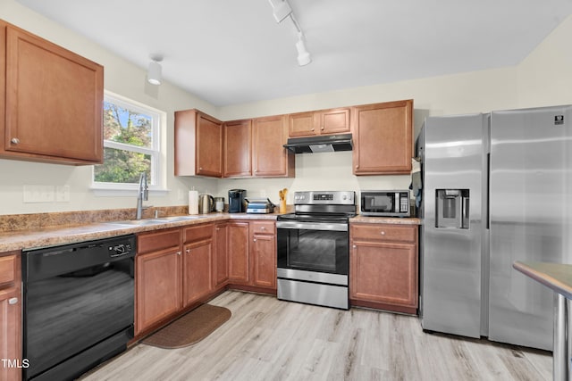 4108 Lady Slipper Ln, Durham, NC 27704 - kitchen with stainless steel appliances, under cabinet range hood, a sink, light wood-style floors, and light countertops