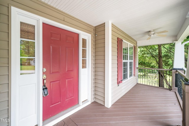 doorway to property featuring covered porch and a ceiling fan