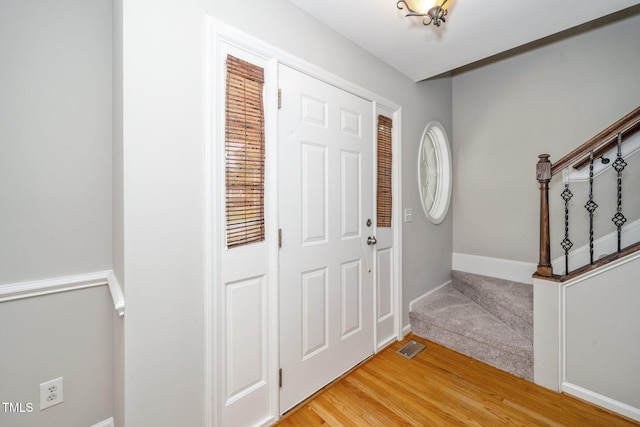entryway featuring stairs, baseboards, and light wood-type flooring