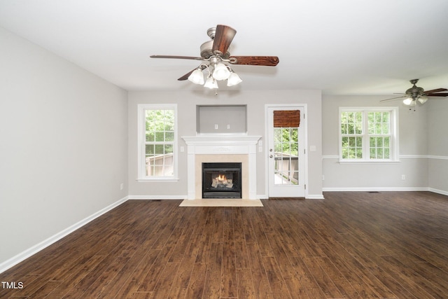 unfurnished living room featuring a ceiling fan, a fireplace with flush hearth, baseboards, and dark wood-style floors