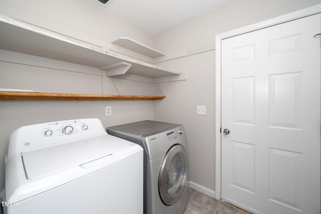 laundry room featuring washer and dryer, baseboards, and light tile patterned floors