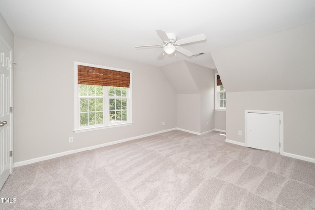bonus room with a ceiling fan, light carpet, baseboards, and lofted ceiling