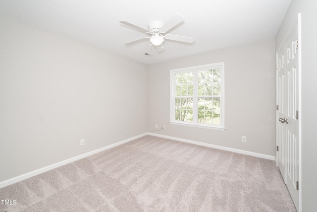 carpeted spare room featuring baseboards and ceiling fan