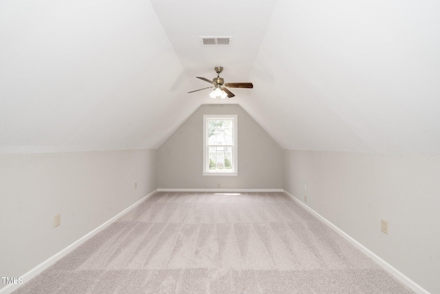 bonus room with light carpet, vaulted ceiling, baseboards, and ceiling fan
