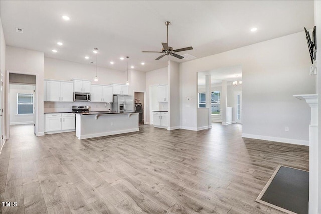 5082 Dogwood Dr, Battleboro, NC 27809 - kitchen with appliances with stainless steel finishes, open floor plan, dark countertops, light wood finished floors, and recessed lighting