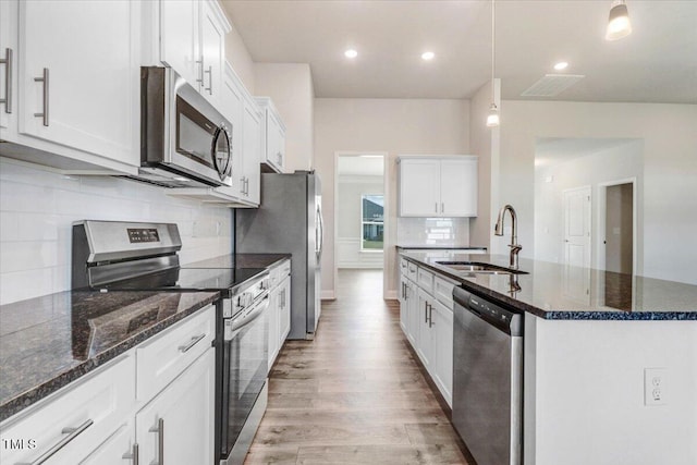 5082 Dogwood Dr, Battleboro, NC 27809 - kitchen featuring a sink, appliances with stainless steel finishes, backsplash, a center island with sink, and light wood-style floors