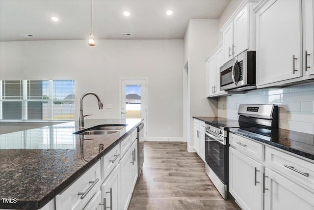 5082 Dogwood Dr, Battleboro, NC 27809 - kitchen featuring appliances with stainless steel finishes, a sink, wood finished floors, backsplash, and white cabinets
