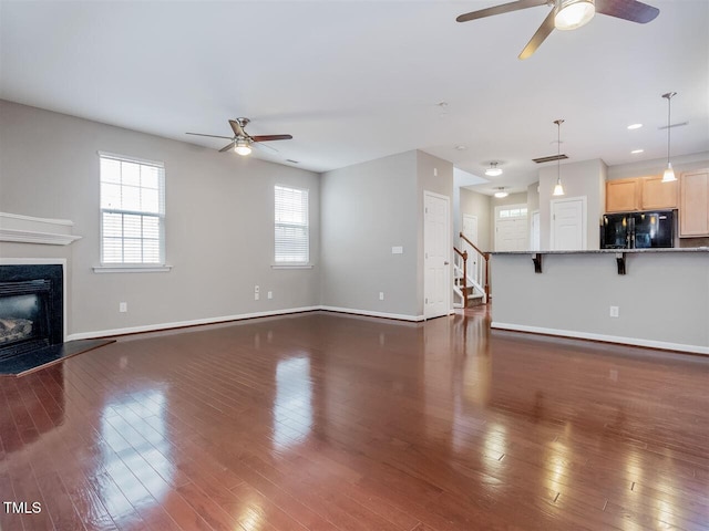 8219 Martello Ln, Raleigh, NC 27613 - unfurnished living room with a ceiling fan, a premium fireplace, baseboards, dark wood finished floors, and stairway