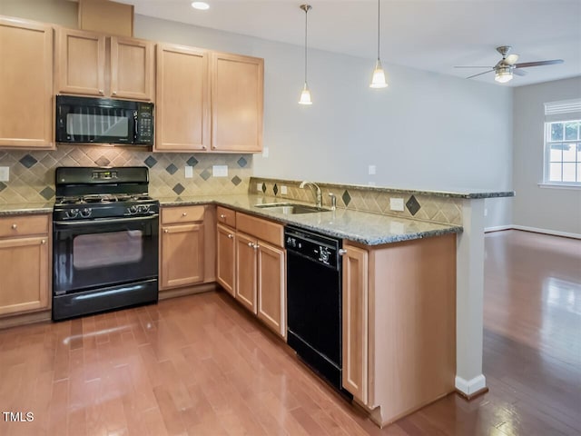8219 Martello Ln, Raleigh, NC 27613 - kitchen with a peninsula, wood finished floors, light brown cabinetry, a sink, and black appliances